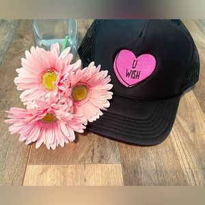 Black trucker hat with adjustable mesh back with pink “u wish”heart.